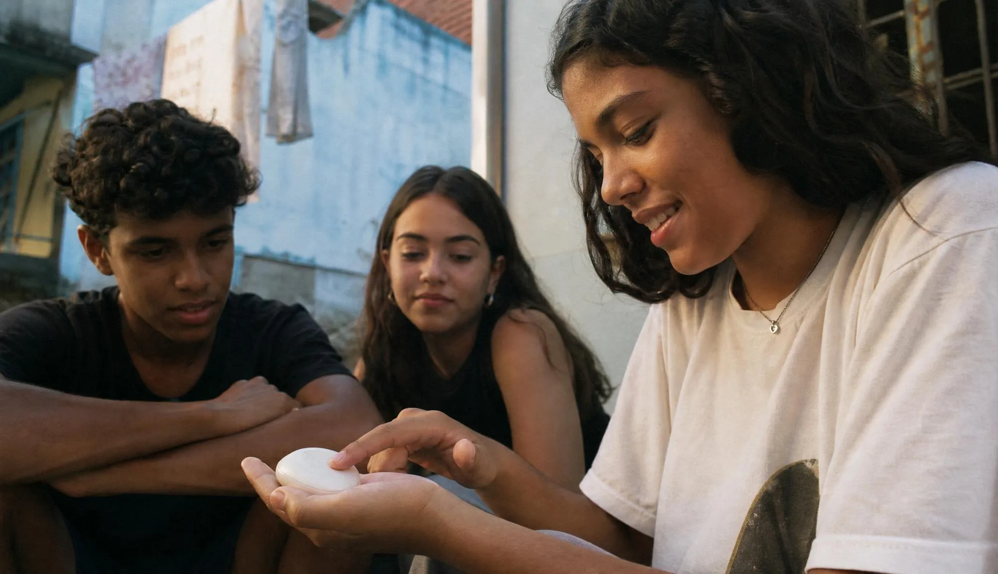Three young people gathered around the device.
